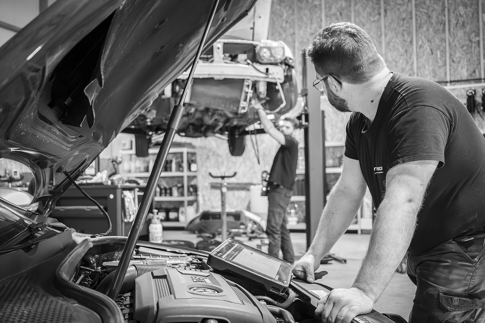 mécanicien réparant moteur dans un garage