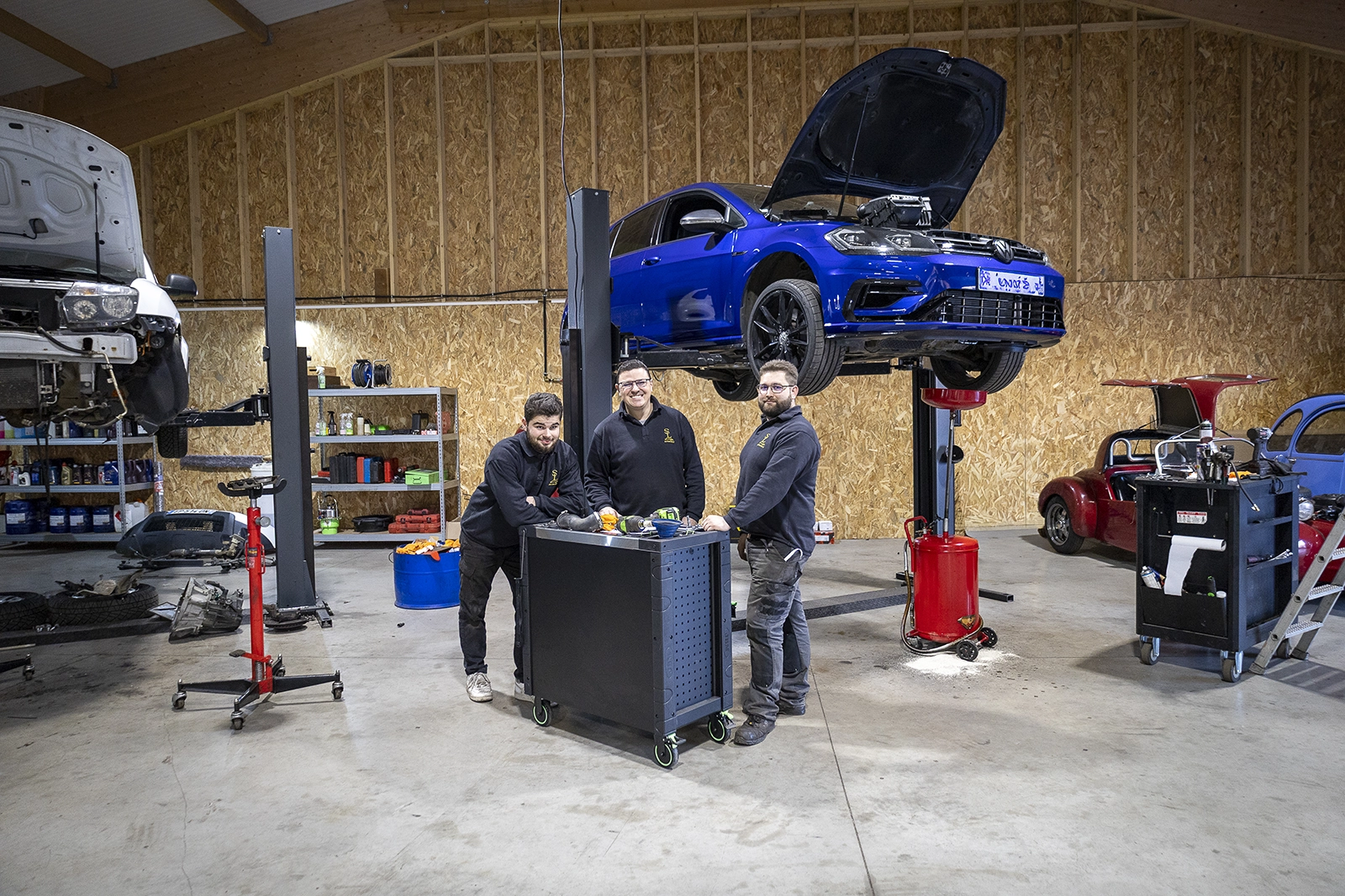 mécaniciens travaillant sur voiture levée