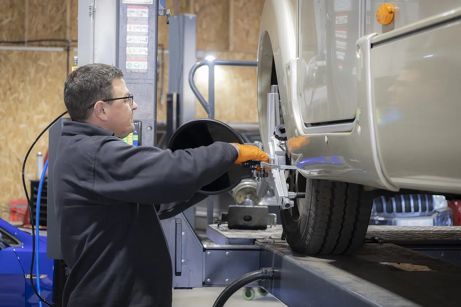 mécanicien contrôlant la roue d’un camping-car sur banc de réglage