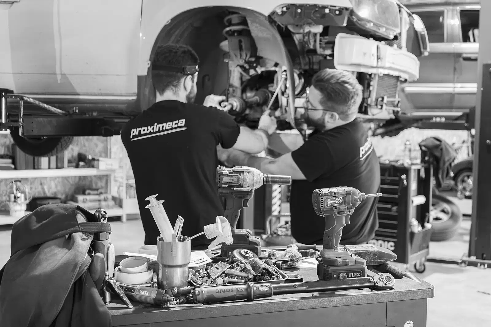 mécaniciens réparant un moteur dans un atelier automobile