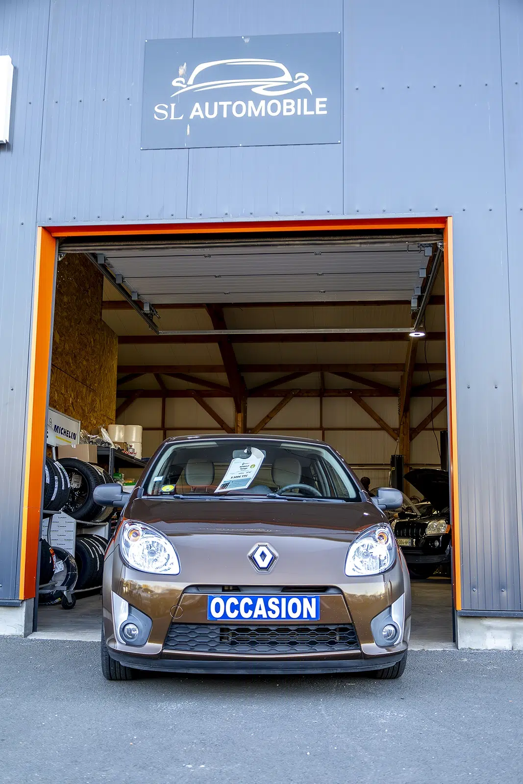 voiture d’occasion devant un garage automobile