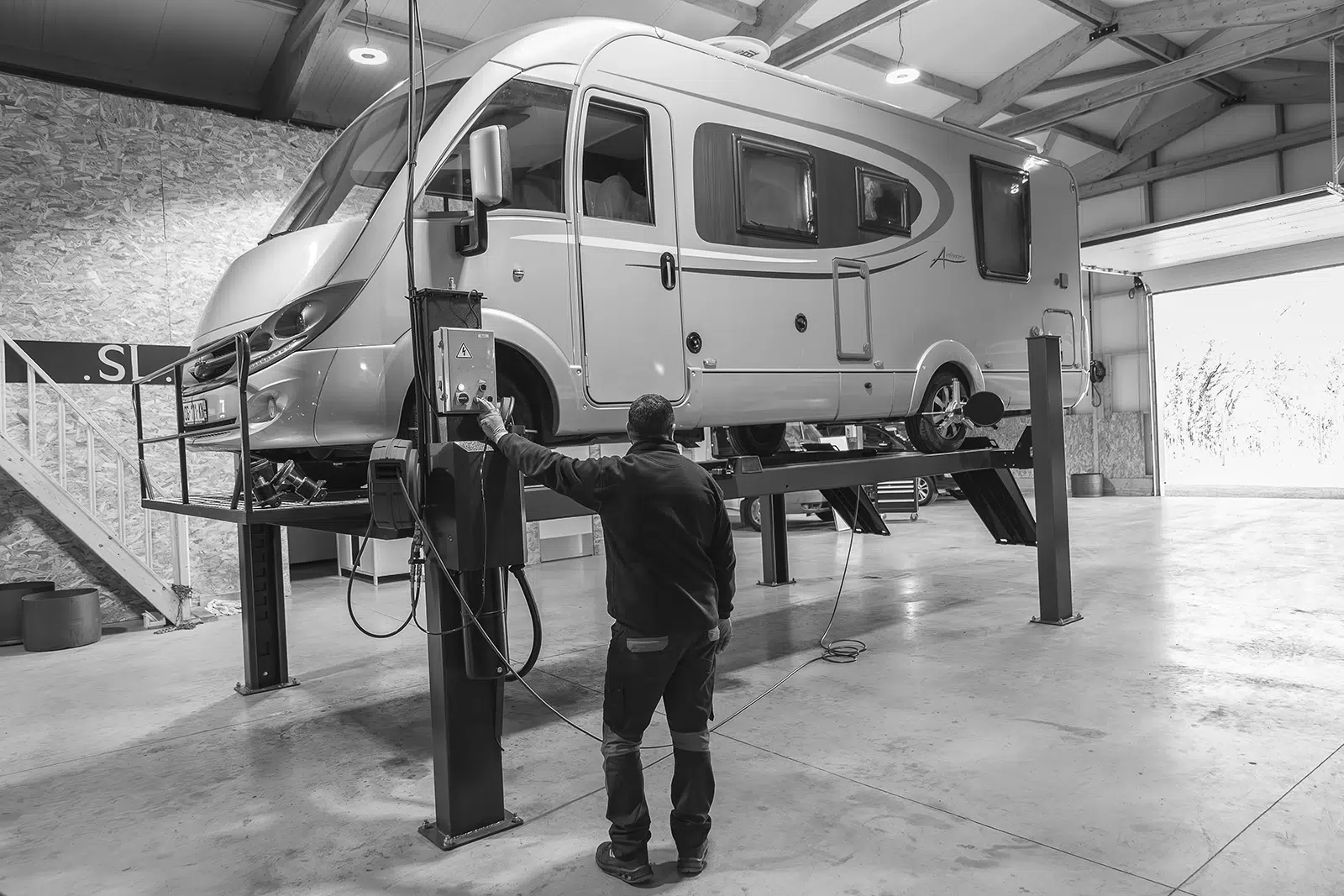 mécanicien réparant un camping-car sur pont